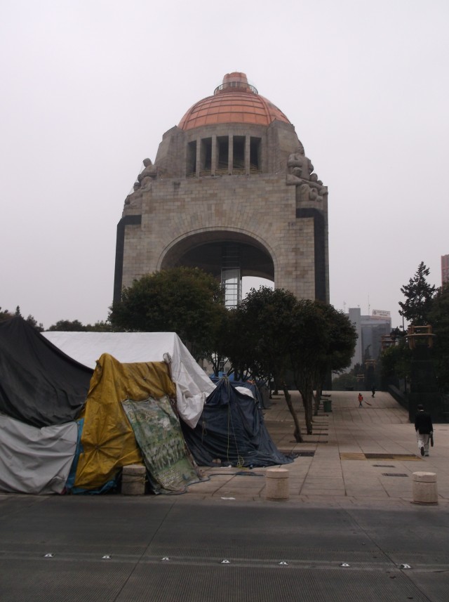 Monument to the Revolution with squatters/protestors in front of them - either way, not all is well with the Republic.
