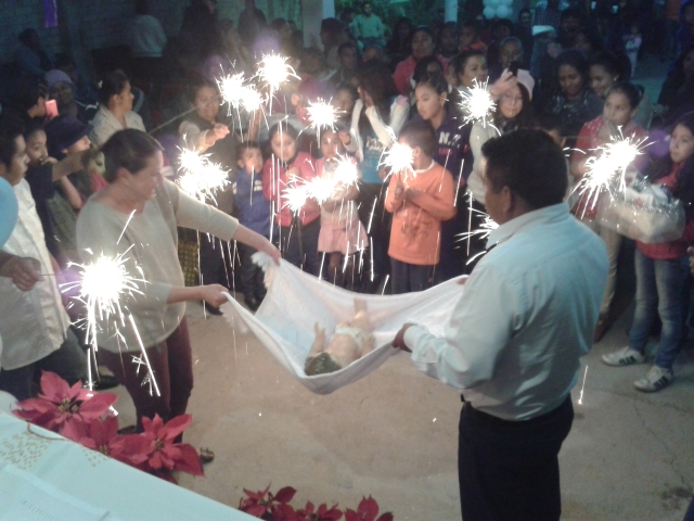 Arrullando (Singing a lullaby to) the Baby Jesus in one of our chapels in Tehuacán on Christmas Eve. With sparklers and whistles as well!!!!